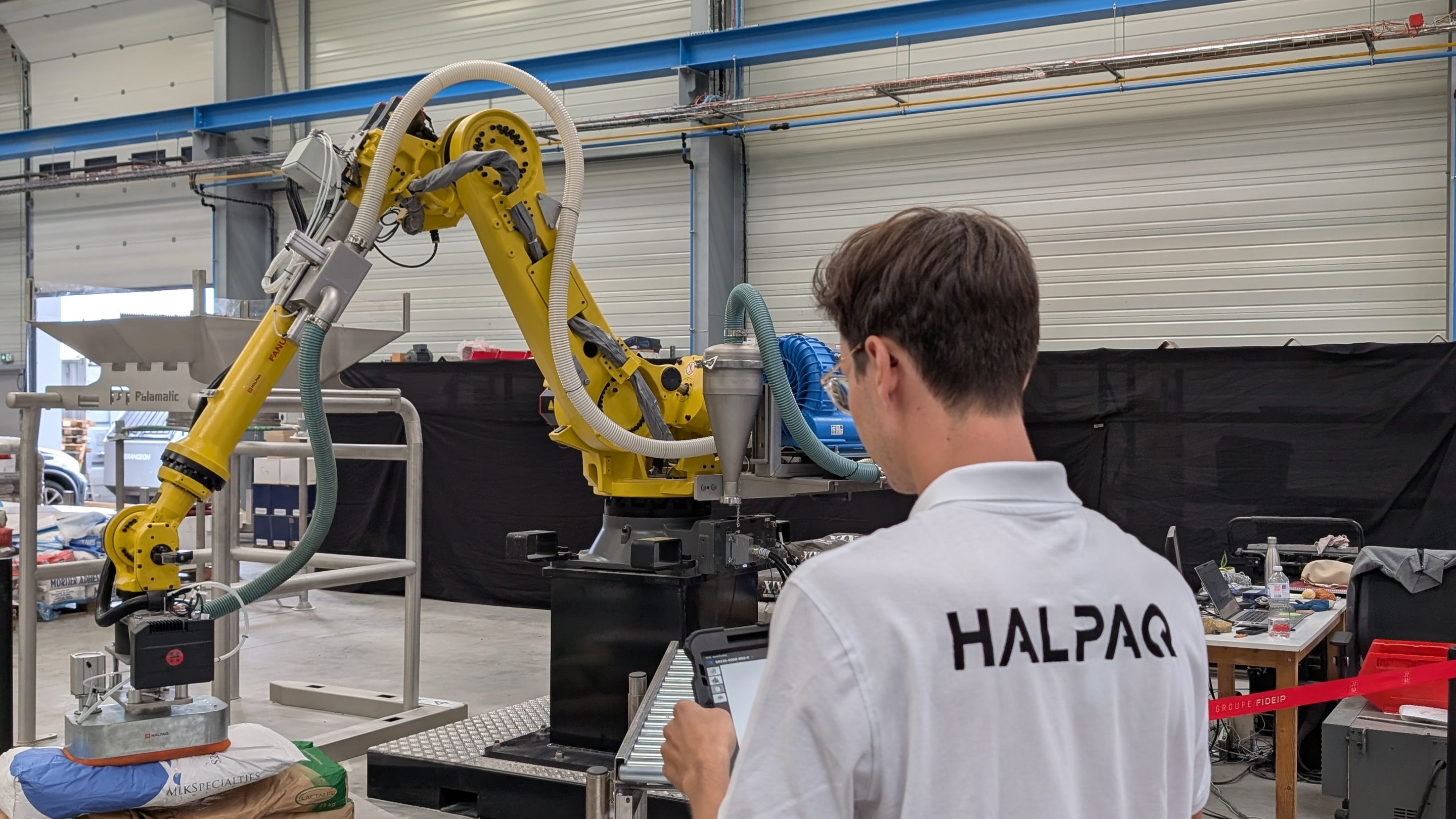 Dépose du sac sur palette pour palettisation de sacs de poudre après conditionneuse hygiénique